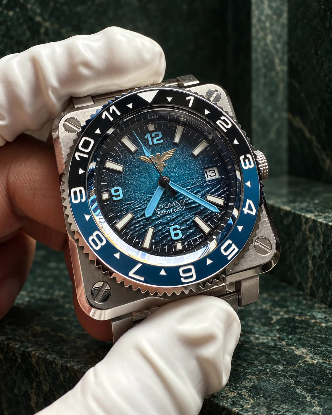 A blue-dial watch being inspected in gloved hands